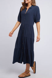 A model wearing the Sunny Days Dress in colour Navy (Blue), from the front, cropped image