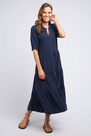 A model wearing the Sunny Days Dress in colour Navy (Blue), from the front, showing the whole outfit