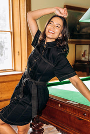 A model wearing the Riva Denim Dress in colour Black (Black), from the front, showing the whole outfit