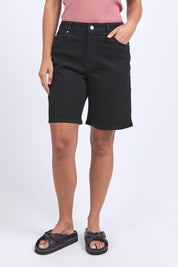 A model wearing the Elements Harley Denim Short in colour Black (Blue), from the front, cropped image