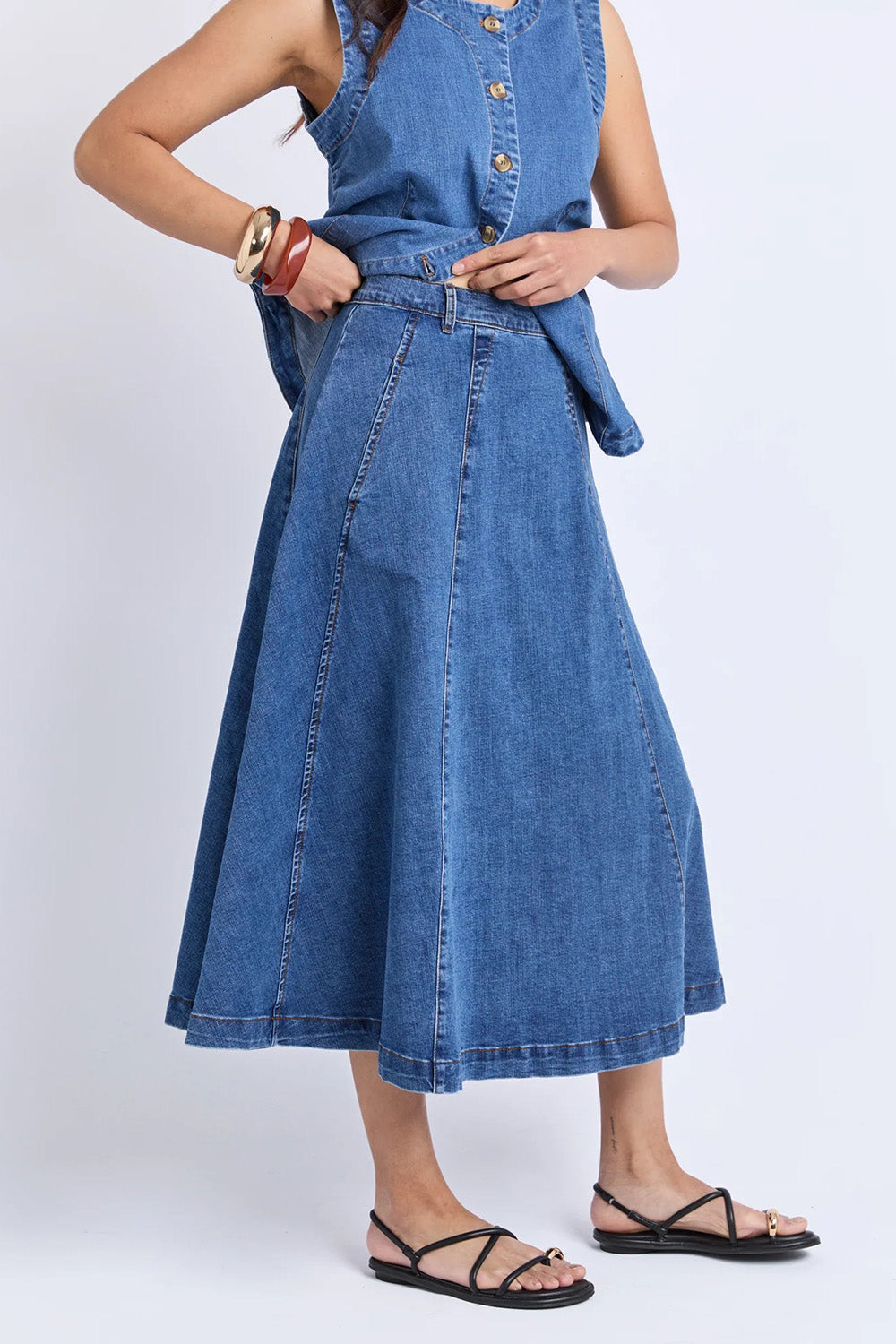 A model wearing the Abbott Denim Skirt in colour Midblue (Blue), from the front, cropped image