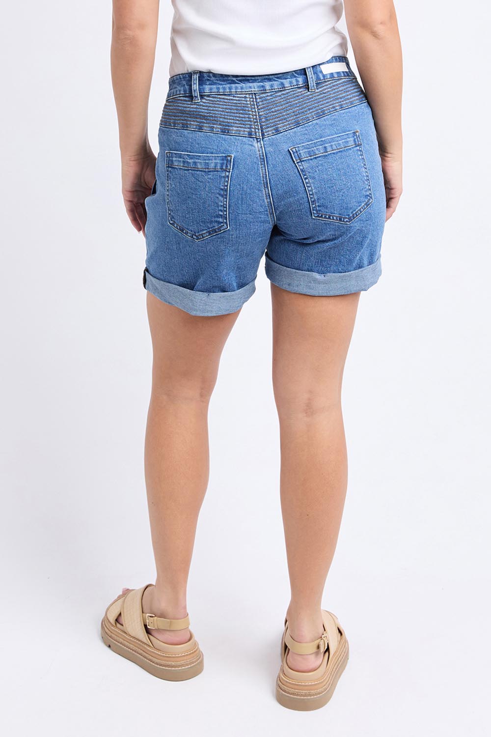 A model wearing the Elements Devi Denim Shorts in colour Midblue (Blue), from the back