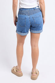 A model wearing the Elements Devi Denim Shorts in colour Midblue (Blue), from the back