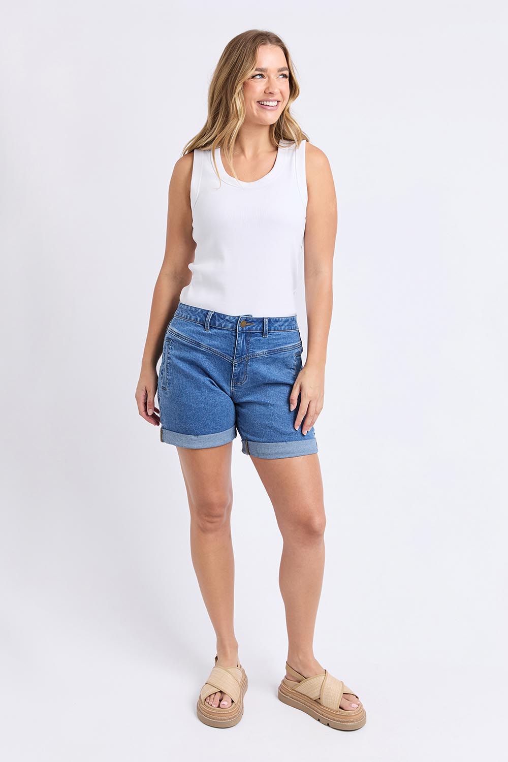A model wearing the Elements Devi Denim Shorts in colour Midblue (Blue), from the front, showing the whole outfit