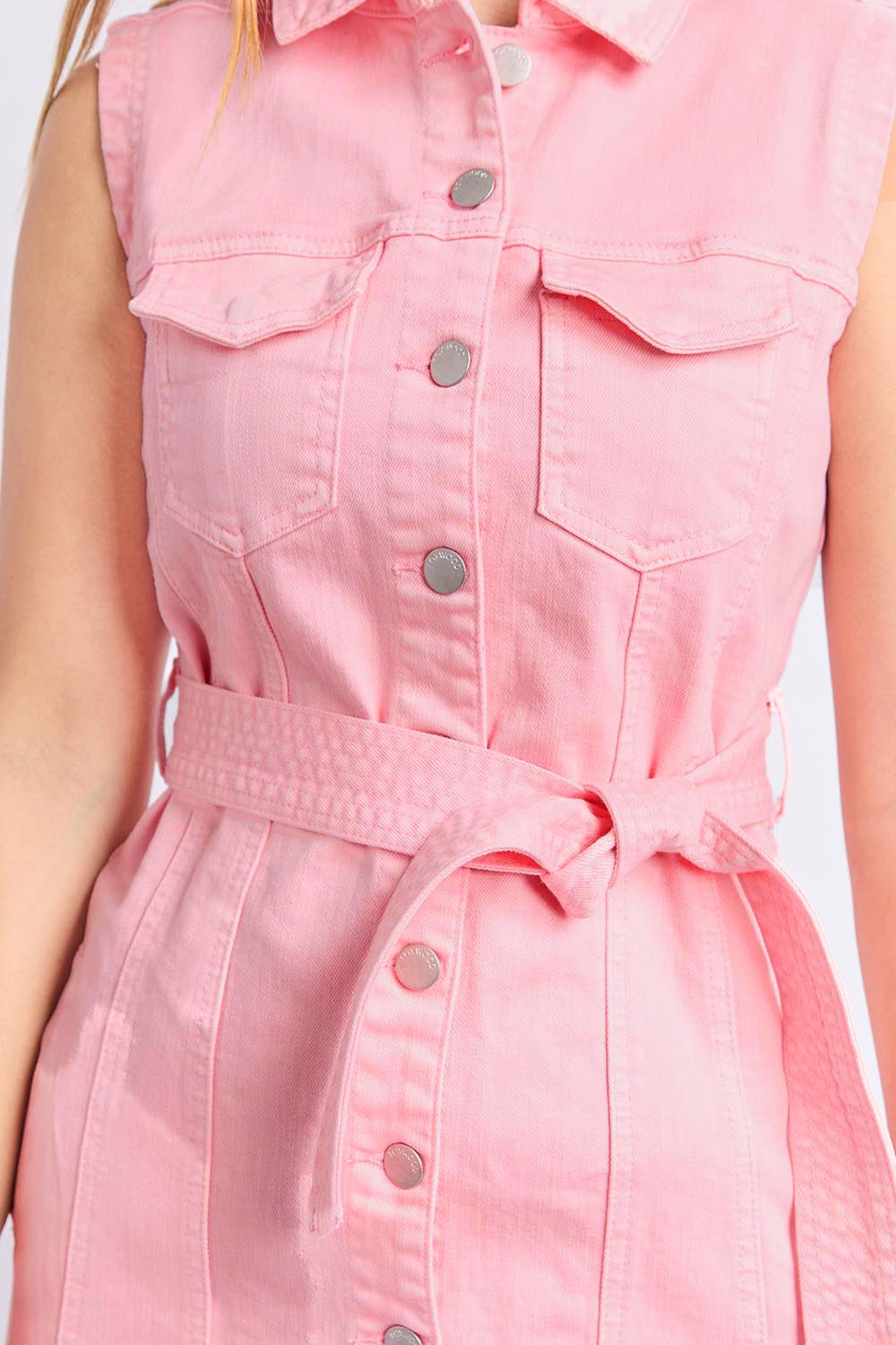 A model wearing the Sleeveless Talbert Denim Dress in colour Palepink (Pink), from the front, cropped image