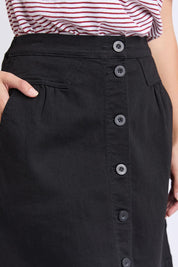 A model wearing the Elements Amanda Denim Skirt in colour Black (Black), from the front, cropped image