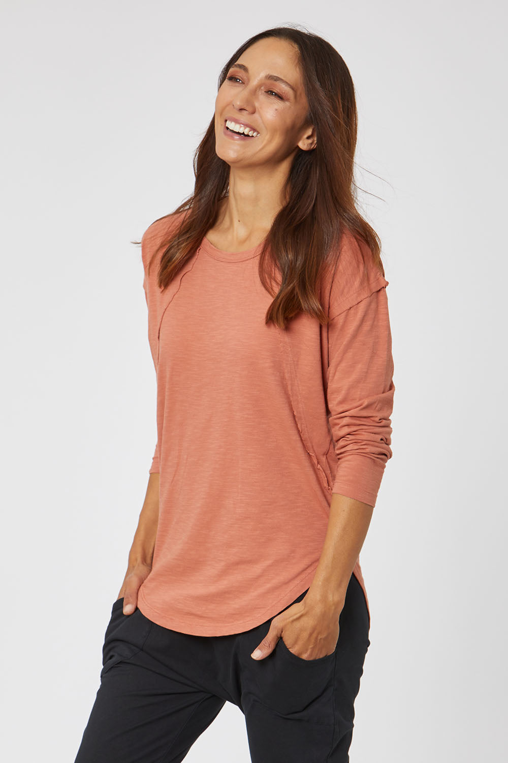 Model Cara wearing size 10 of the Elements Mackenzie Long Sleeve Crew Tee in colour Copper, from the front, cropped image