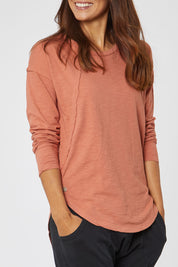 Model Cara wearing size 10 of the Elements Mackenzie Long Sleeve Crew Tee in colour Copper, from the front, cropped image