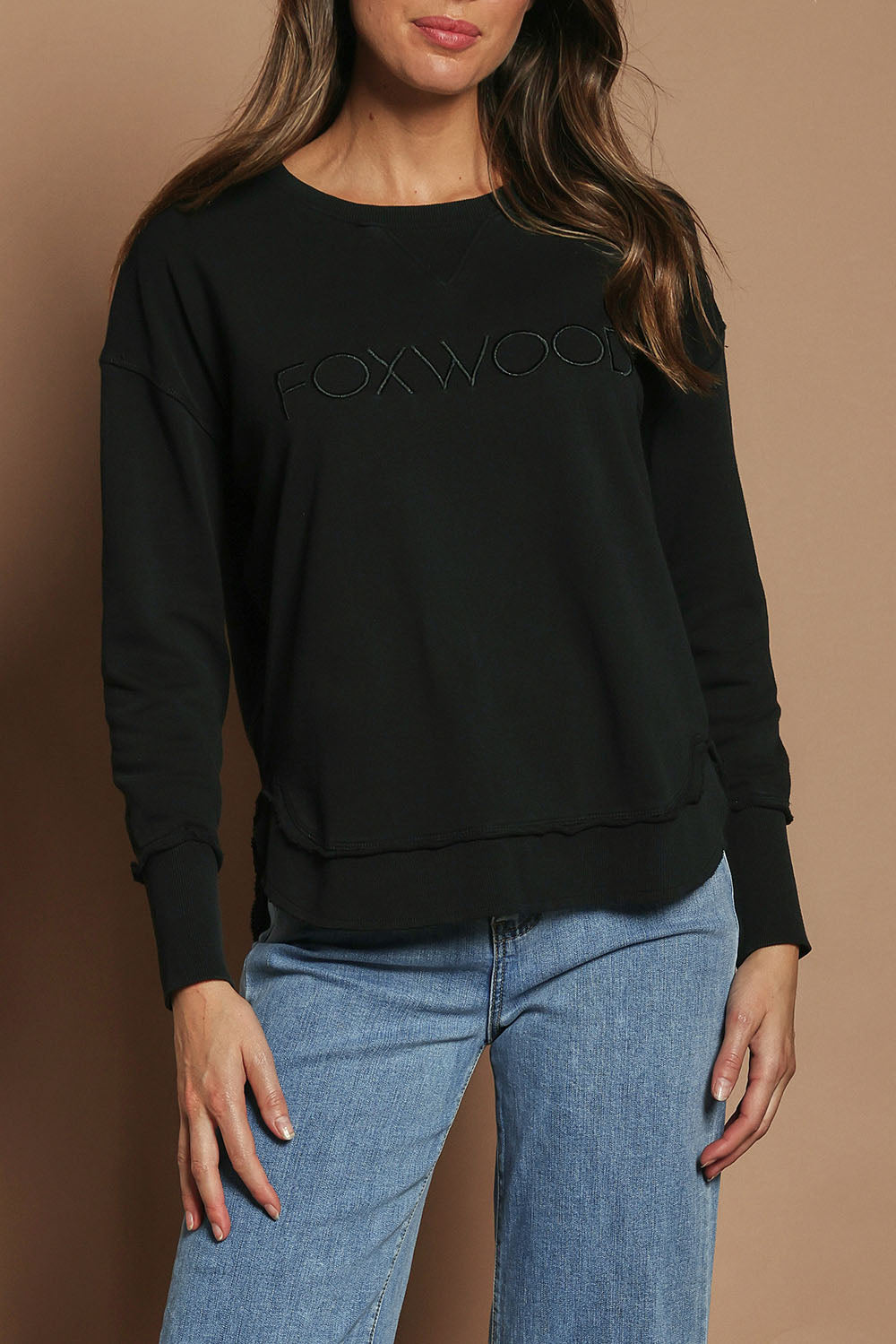 Model Madeline wearing size 10 of the Elements Simplified Cotton Crew in colour Black (Black), from the front, cropped image