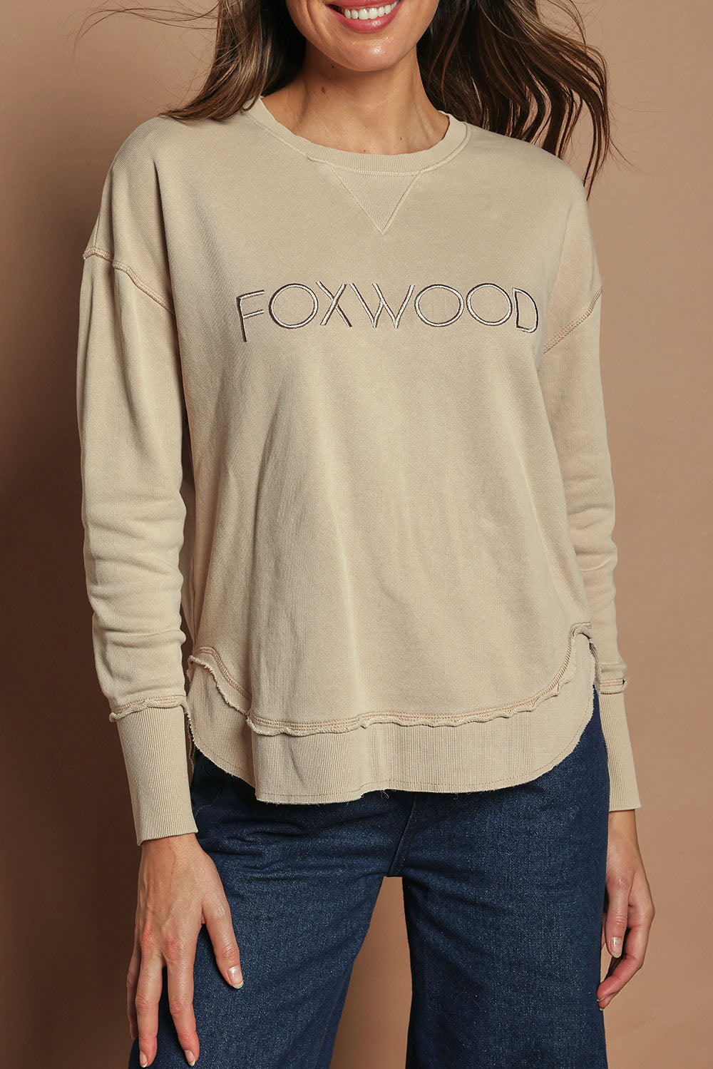 Model Madeline wearing size 10 of the Elements Simplified Cotton Crew in colour Oat, from the front, cropped image