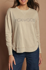 Model Madeline wearing size 10 of the Elements Simplified Cotton Crew in colour Oat, from the front, cropped image