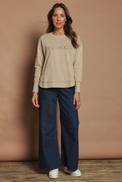 Model Madeline wearing size 10 of the Elements Simplified Cotton Crew in colour Oat, from the front, showing the whole outfit