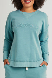 Model Olivia wearing size 10 of the Elements Simplified Cotton Crew in colour Sky (Blue), from the front, cropped image