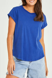 Model Elhana wearing size 10 of the Elements Manly Cotton Tee in colour Tranblue (Blue), from the front, cropped image