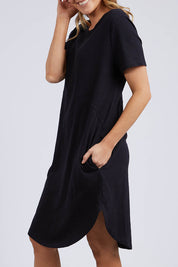 A model wearing the Elements Bay Cotton Dress in colour Black (Black), from the front, cropped image