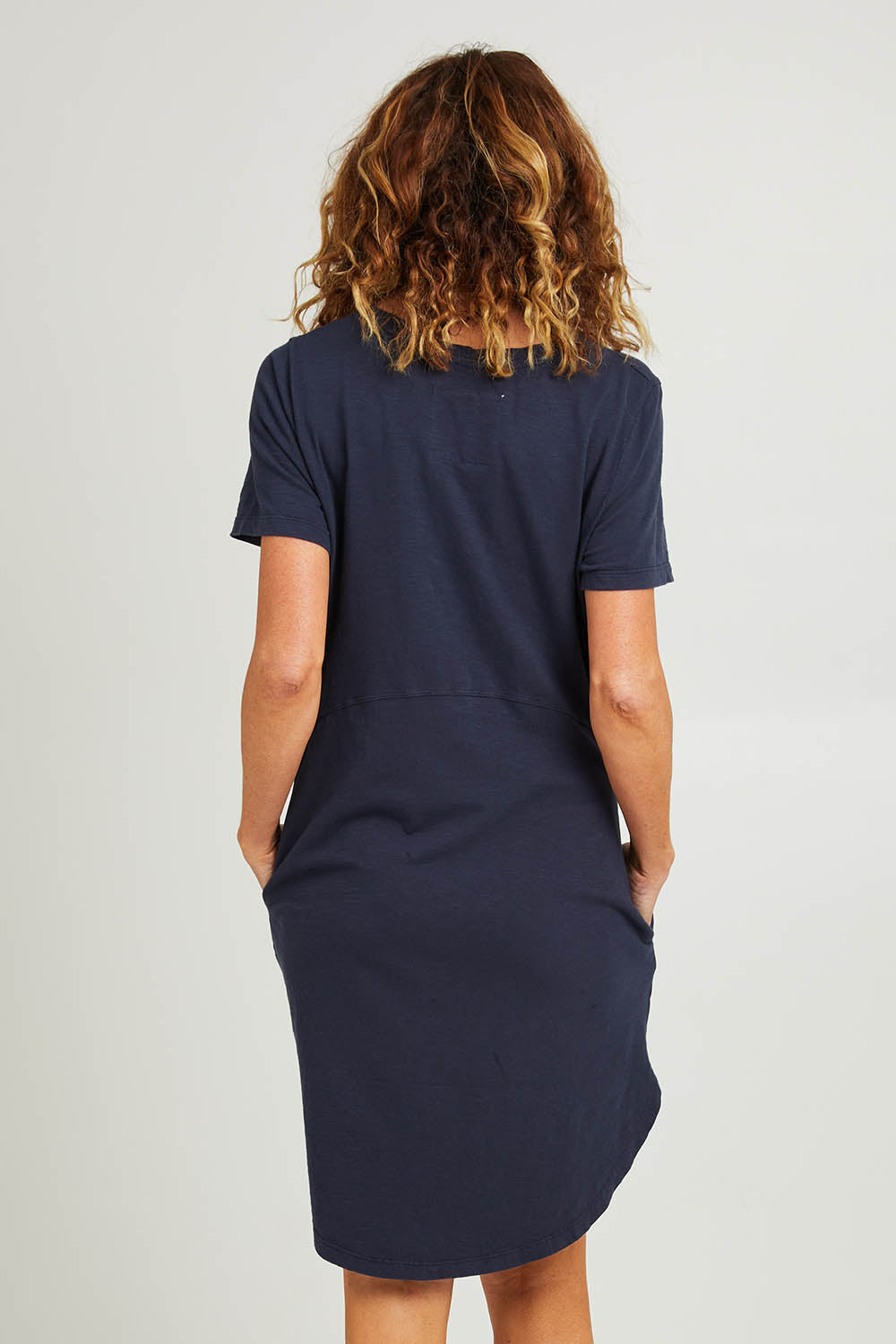 Model Emma wearing size 10 of the Elements Bay Cotton Dress in colour Sapphire (Blue), from the back
