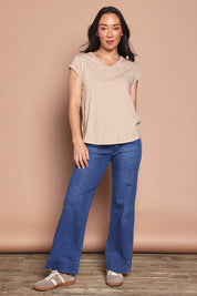 Model Katie wearing size 8 of the Elements Manly Cotton Vee Tee in colour Oat, from the front, showing the whole outfit