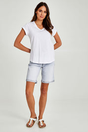 Model Madeline wearing size 10 of the Elements Manly Cotton Vee Tee in colour White (White), from the front, showing the whole outfit