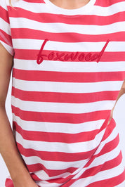 A model wearing the Elements Signature Tee Dress in colour Cayennewhi (Red), from the front, cropped image