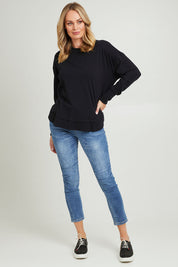 Model Grace wearing size 10 of the Elements Farrah Cotton Long Sleeve in colour Black (Black), from the front, showing the whole outfit