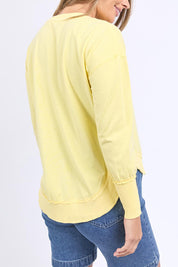 A model wearing the Elements Farrah Cotton Long Sleeve in colour Lemon, from the back