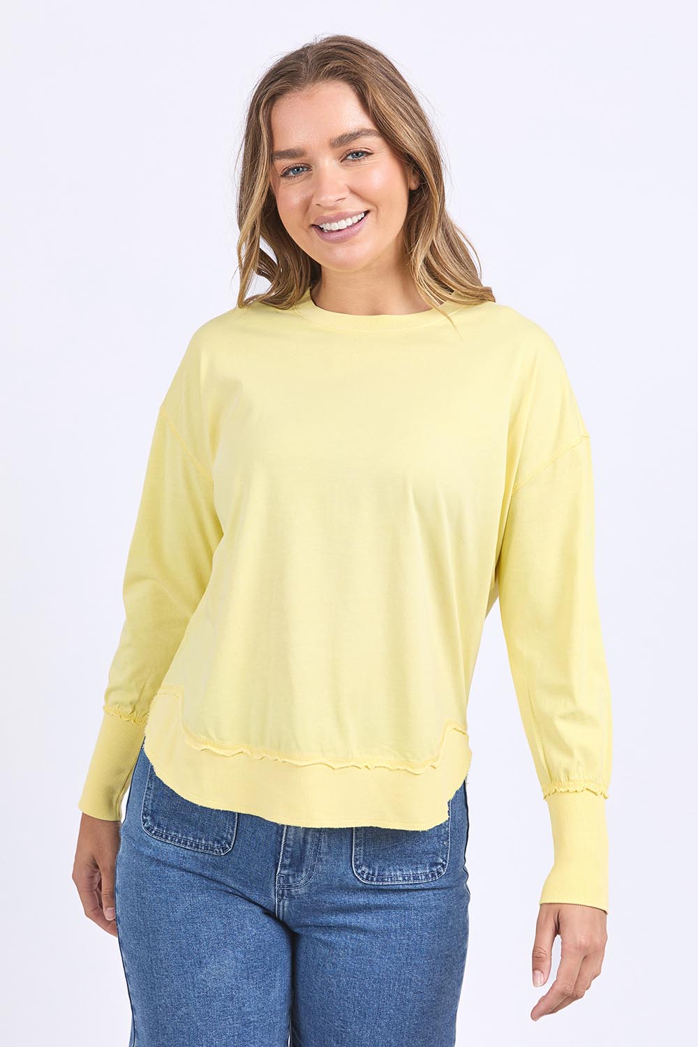 A model wearing the Elements Farrah Cotton Long Sleeve in colour Lemon, from the front, cropped image