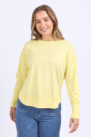 A model wearing the Elements Farrah Cotton Long Sleeve in colour Lemon, from the front, cropped image