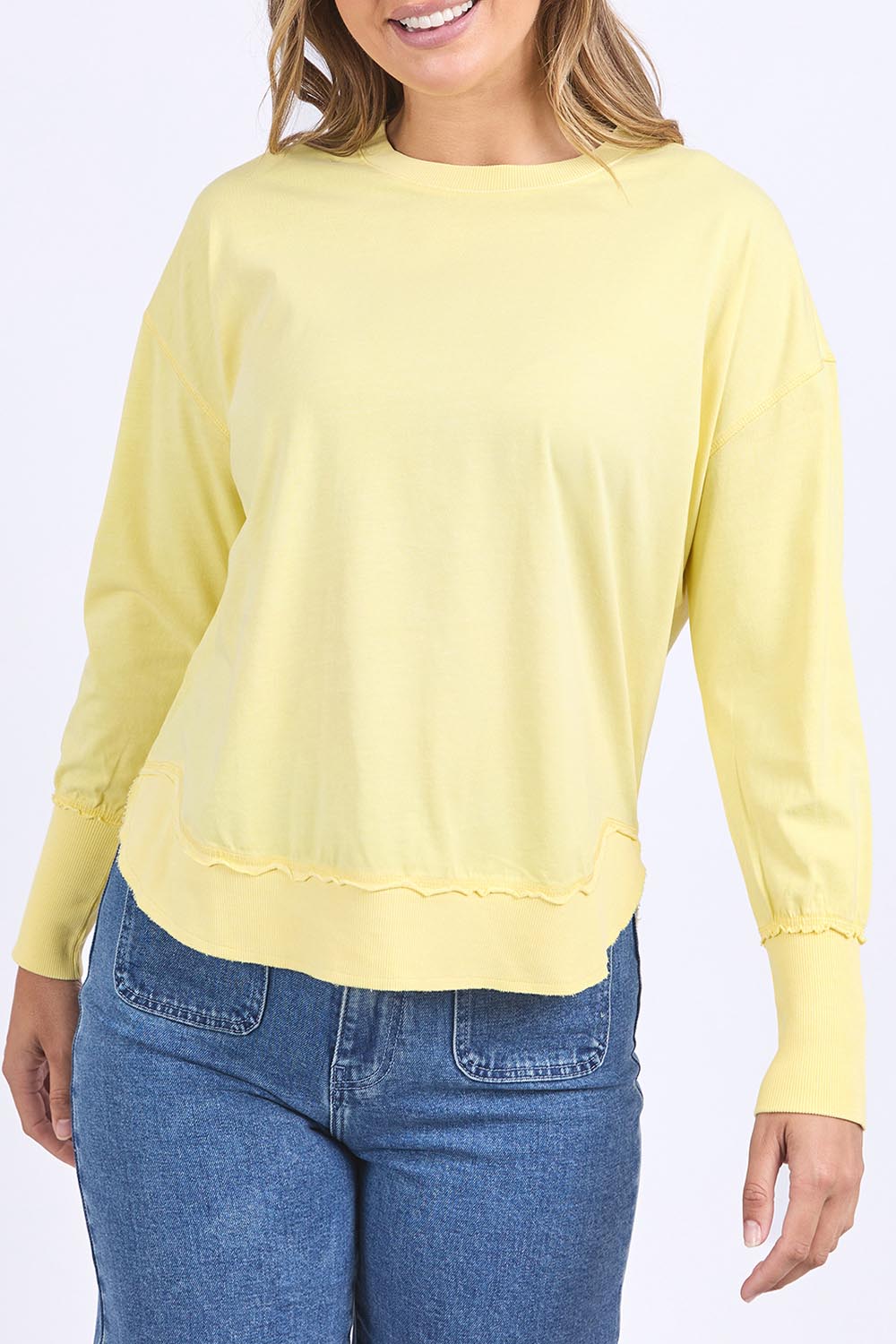 A model wearing the Elements Farrah Cotton Long Sleeve in colour Lemon, from the front, cropped image