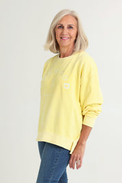 Model Sandy wearing size 10 of the Effortless Cotton Crew in colour Lemon, from the front, cropped image
