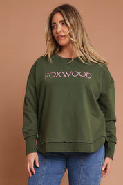 Model Chanel wearing size 16 of the Elements Simplified Metallic Cotton Crew in colour Olivepink (Green), from the front, cropped image