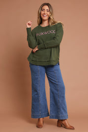 Model Chanel wearing size 16 of the Elements Simplified Metallic Cotton Crew in colour Olivepink (Green), from the front, showing the whole outfit