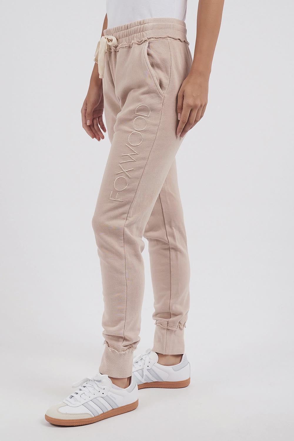A model wearing the Leisure Simplified Pants in colour Oatmeal, from the front, cropped image