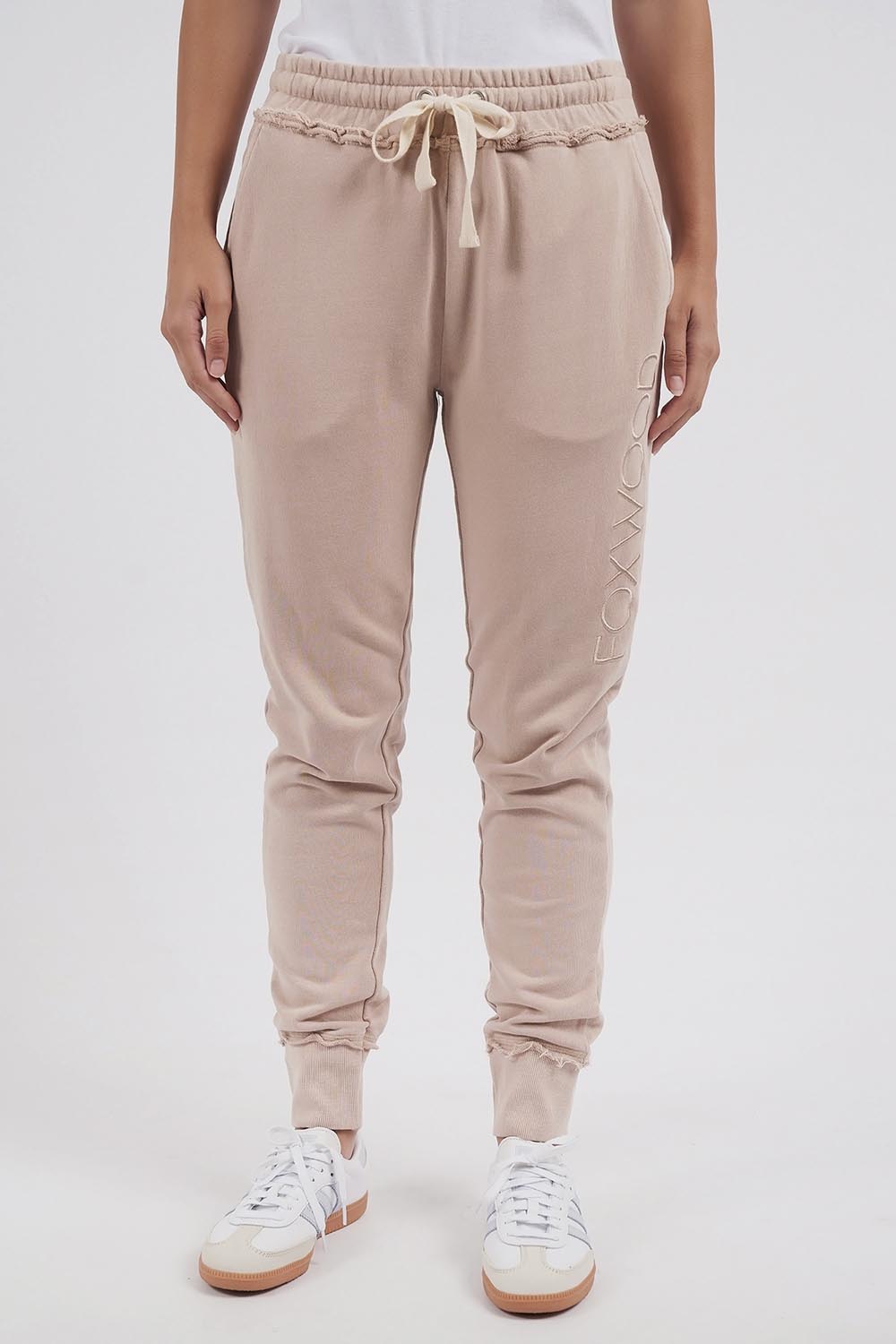 A model wearing the Leisure Simplified Pants in colour Oatmeal, from the front, cropped image