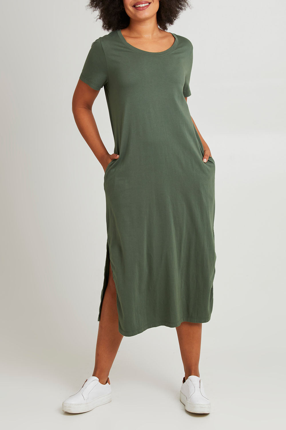 Model Olivia wearing size 10 of the Elements Rhythm Dress in colour Khaki (Green), from the front, cropped image