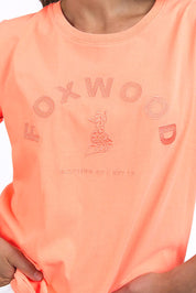 A model wearing the Elements Effortless Tee in colour Neonpeach, from the front, cropped image