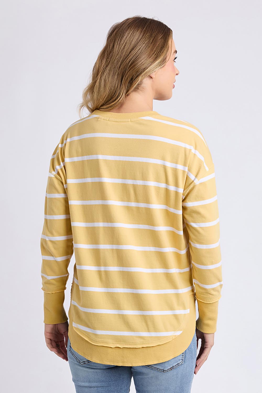 A model wearing the Elements Farrah Stripe Cotton Long Sleeve in colour Butterwhit, from the back