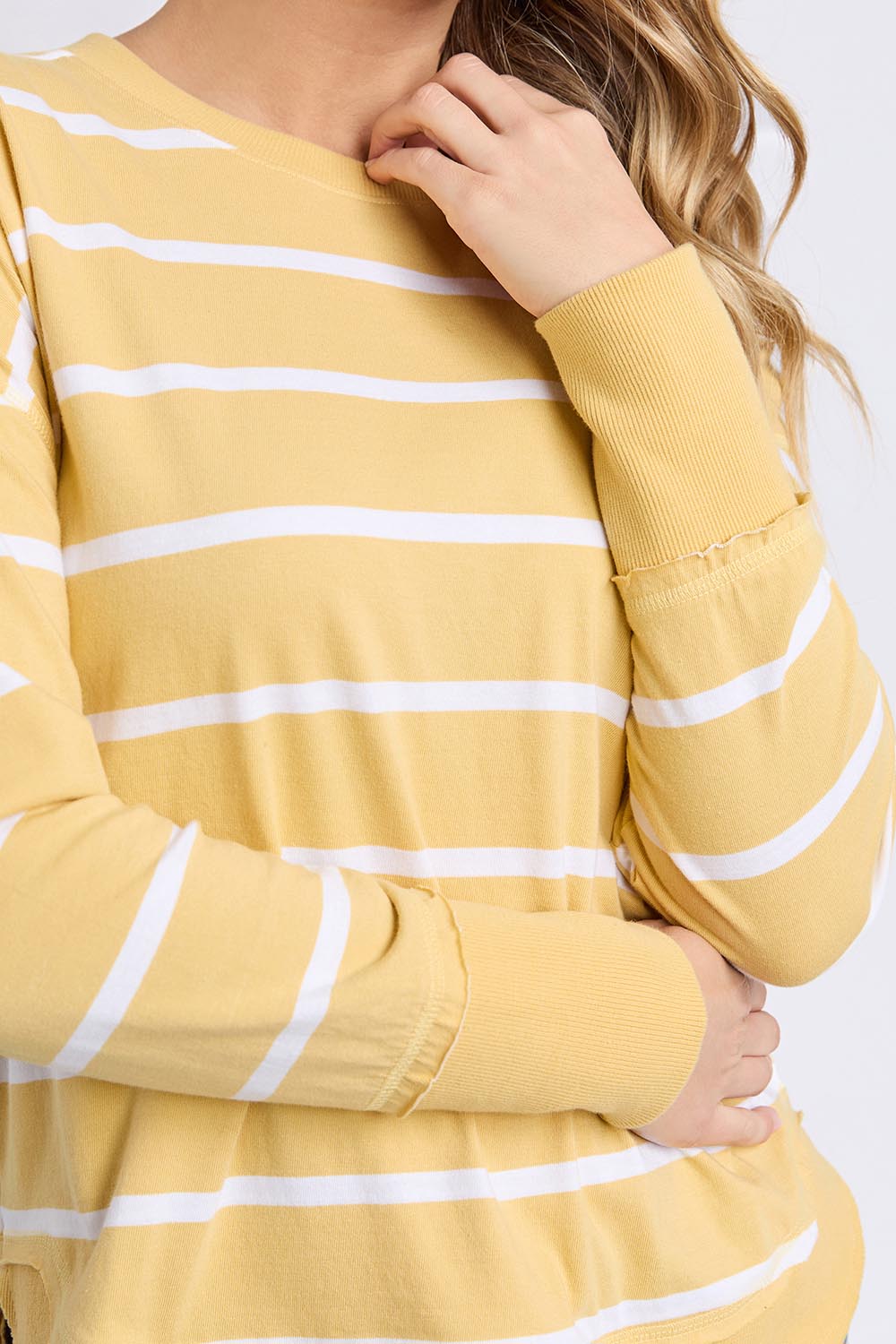 A model wearing the Elements Farrah Stripe Cotton Long Sleeve in colour Butterwhit, from the front, cropped image