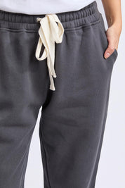 A model wearing the Elements Cotton College Track Pant in colour Coal (Grey), from the front, cropped image