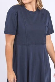 A model wearing the Elements Eva Cotton Dress in colour Navy (Blue), from the front, cropped image