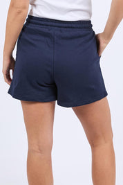 A model wearing the Elements Simplified Confetti Cotton Shorts in colour Navy (Blue), from the back