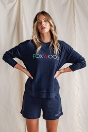A model wearing the Elements Simplified Confetti Cotton Shorts in colour Navy (Blue), from the front, showing the whole outfit