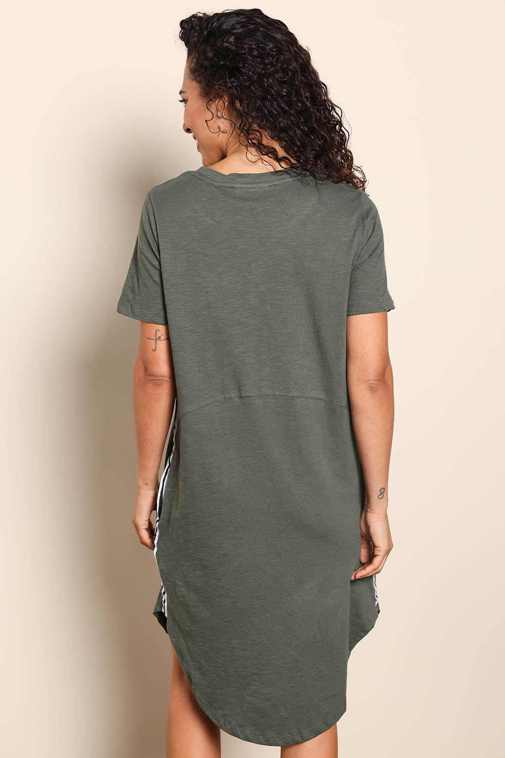 Model Pamelar wearing size 10 of the Elements Bay Tape Cotton Tee Dress - Khaki in colour Khaki, from the back
