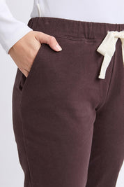 A model wearing the Elements Monday Cotton Pant in colour Coffee, from the front, cropped image