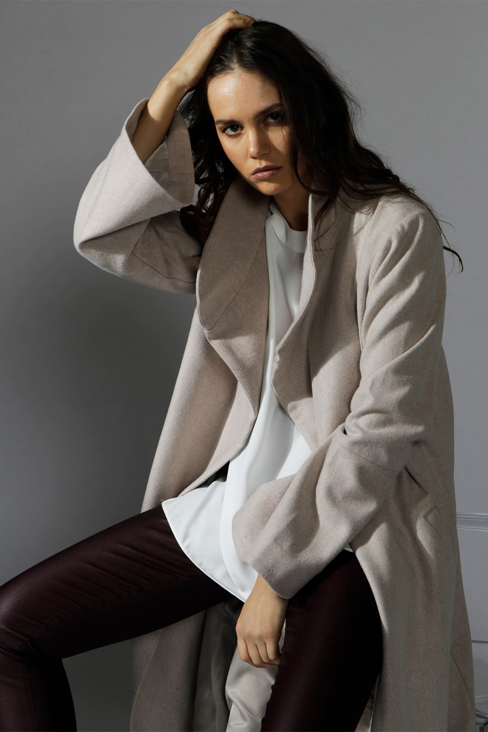 A model wearing the Maniaa Long Coat in colour Chestnut, from the front, showing the whole outfit