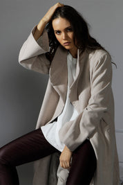 A model wearing the Maniaa Long Coat in colour Chestnut, from the front, showing the whole outfit