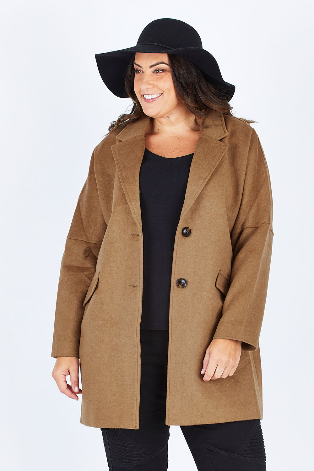 Model Stacey wearing size L of the Ascot Coat in colour Caramel, from the front, cropped image