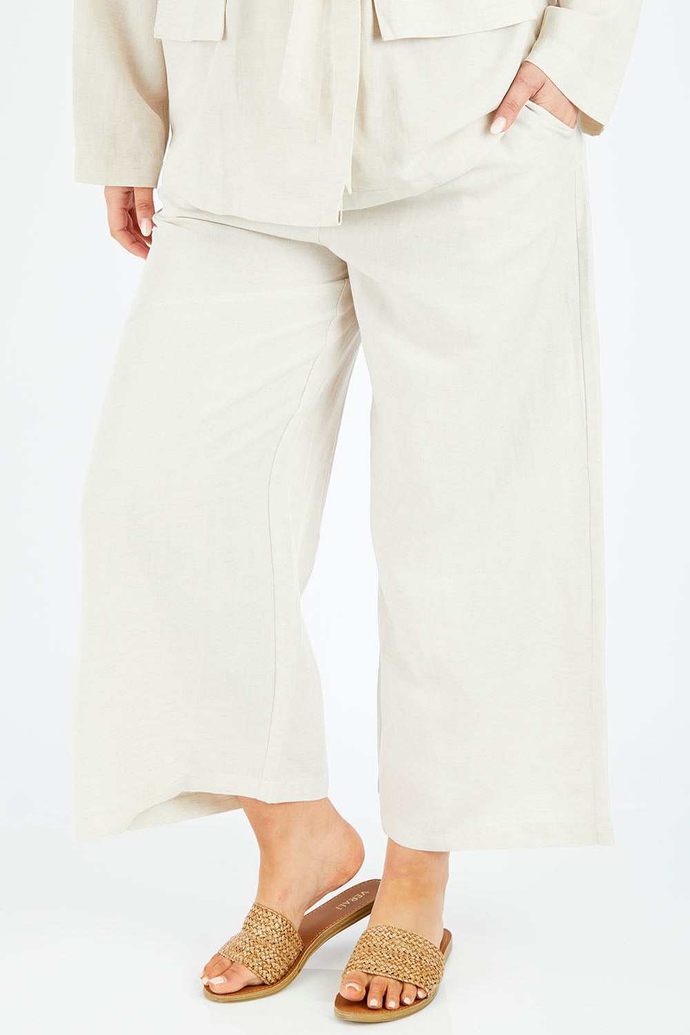 Model Jess wearing size 14 of the Sea Ya Wide Leg Pant in colour Almond (White), from the front, cropped image