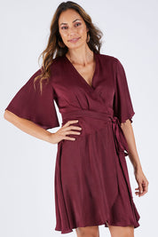 Model Amanda wearing size 10 of the Roula Wrap Dress in colour Portwine (Red), from the front, cropped image