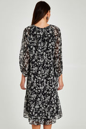 Model Madeline wearing size 10 of the Beautiful Soul Frill Hem Midi Dress in colour Monofloral (Black), from the back