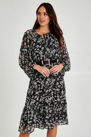 Model Madeline wearing size 10 of the Beautiful Soul Frill Hem Midi Dress in colour Monofloral (Black), from the front, cropped image